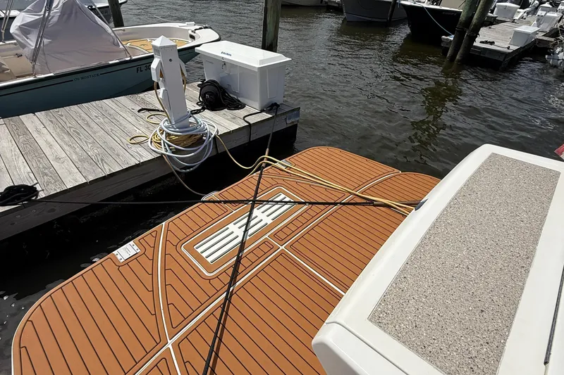 Slide: The Image of 2015 Sea Ray 350 Sundancer docked, showing swim platform and marina setup. - 7