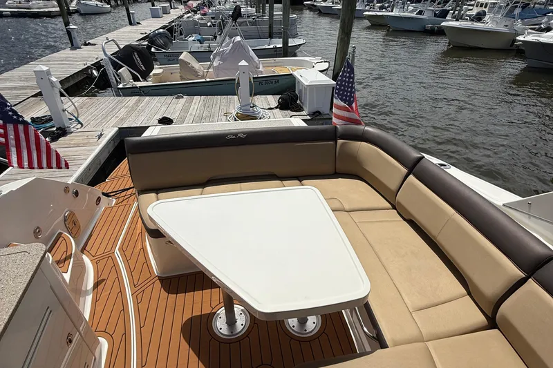 Slide: The Image of 2015 Sea Ray 350 Sundancer boat with seating area and table at marina dock. - 9
