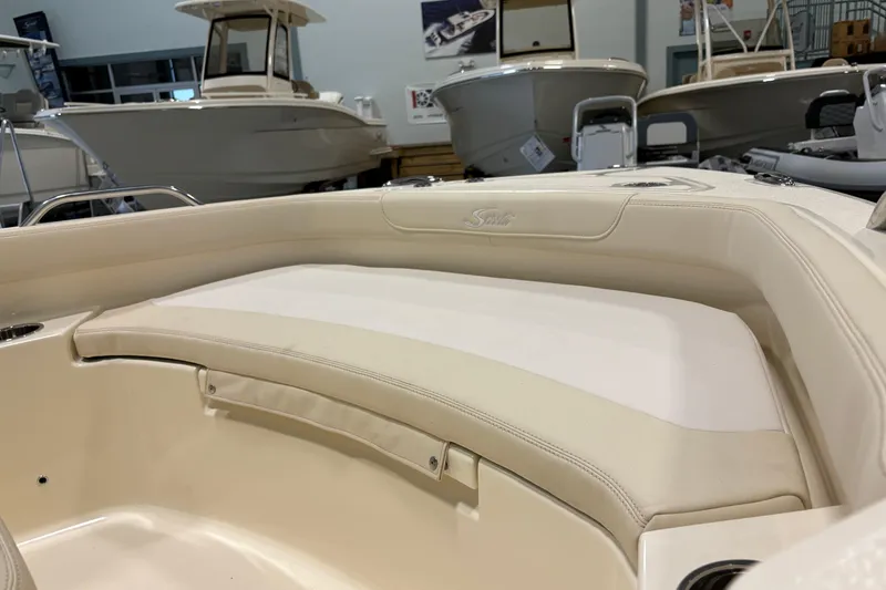 Slide: The Image of 2026 Scout 188 Sportfish boat interior with beige seating in showroom. - 10