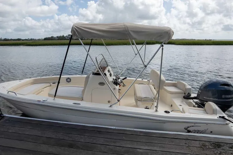 Slide: The Image of 2026 Scout 188 Sportfish boat docked by a serene lake under cloudy skies. - 15