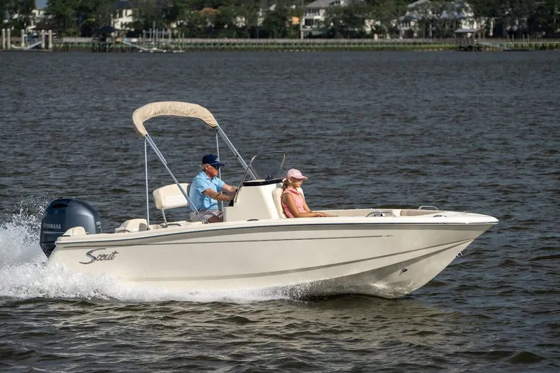 Slide: The Image of 2026 Scout 188 Sportfish boat cruising on a calm lake with two passengers. - 19