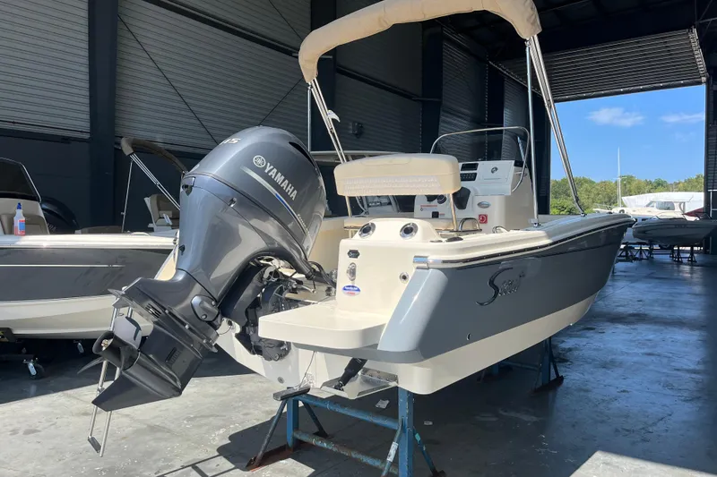 Slide: The Image of 2026 Scout 188 Sportfish boat displayed indoors, front view. - 2