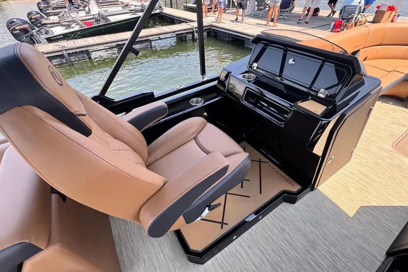 Slide: The Image of Luxurious helm of 2026 Veranda Vertex VX285DCRC boat with tan seating and sleek controls. - 12