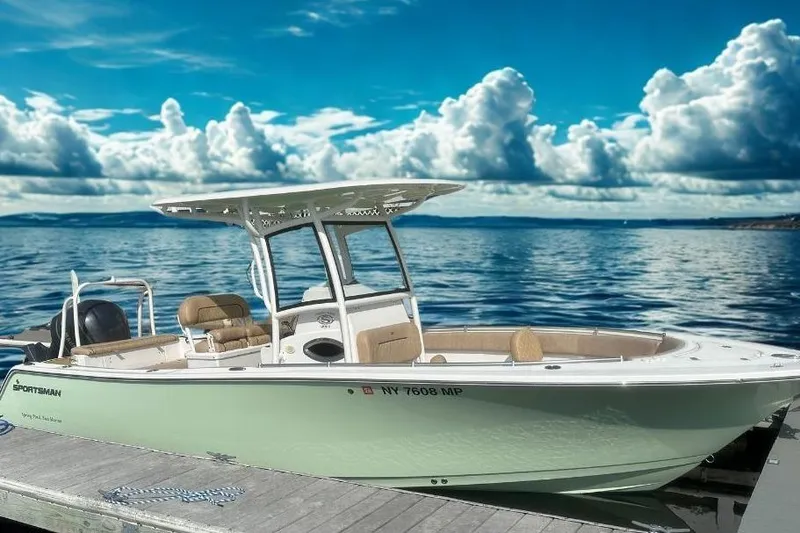 The Image of 2020 Sportsman Heritage 251 Center Console boat docked on a serene lake under a cloudy sky. - 1