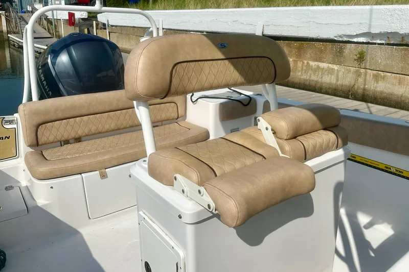Slide: The Image of 2020 Sportsman Heritage 251 Center Console boat interior with tan cushioned seating. - 13