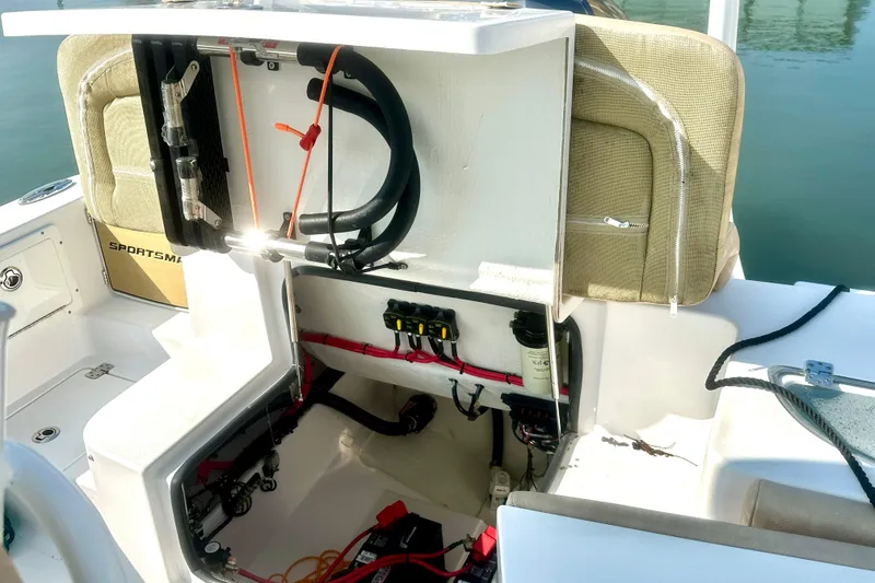 Slide: The Image of 2020 Sportsman Heritage 251 Center Console boat with open storage compartment and visible wiring. - 15