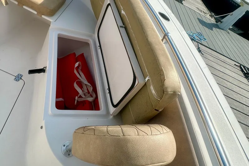 Slide: The Image of 2020 Sportsman Heritage 251 Center Console with open storage compartment and red life jacket. - 16