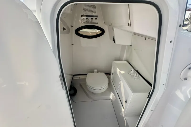 Slide: The Image of 2020 Sportsman Heritage 251 Center Console boat interior with toilet and storage. - 21