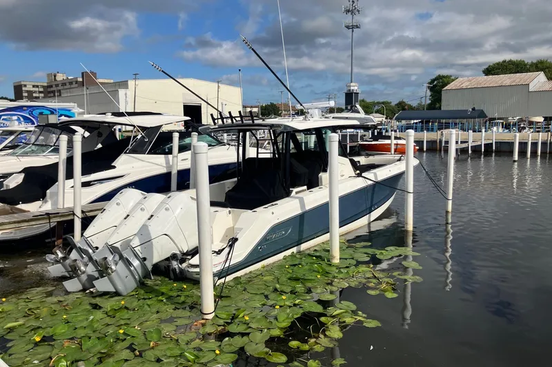 The Image of 2025 Boston Whaler 360 Outrage docked at marina, surrounded by lily pads. - 0