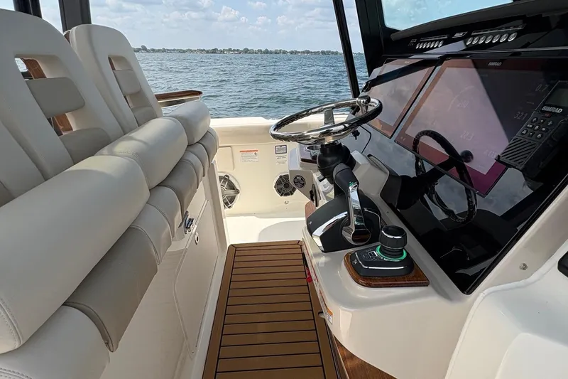 Slide: The Image of 2025 Boston Whaler 360 Outrage helm with modern controls and ocean view. - 10