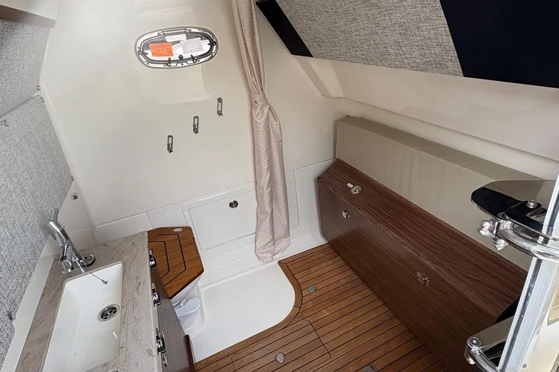 Slide: The Image of Interior of 2025 Boston Whaler 360 Outrage, featuring wood accents and modern fixtures. - 14