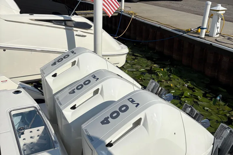 Slide: The Image of Boston Whaler 360 Outrage 2025 with triple Mercury 400 engines docked by lily pads. - 4