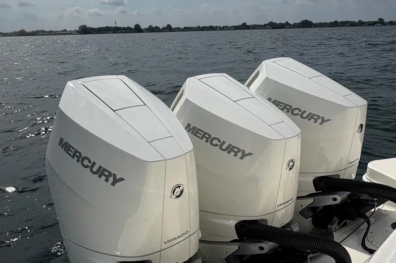 Slide: The Image of Triple Mercury Verado engines on a 2025 Boston Whaler 360 Outrage, cruising on a lake. - 5