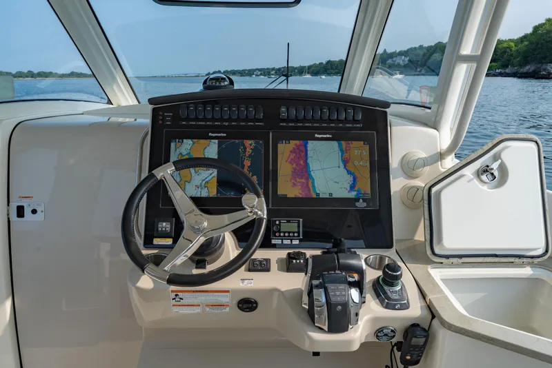 Slide: The Image of 2019 Boston Whaler 350 EX REALM helm with navigation screens and steering wheel. - 11
