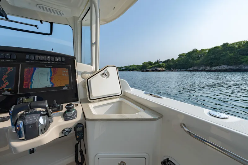 Slide: The Image of 2019 Boston Whaler 350 EX REALM cockpit with navigation screens, steering, and scenic water view. - 12