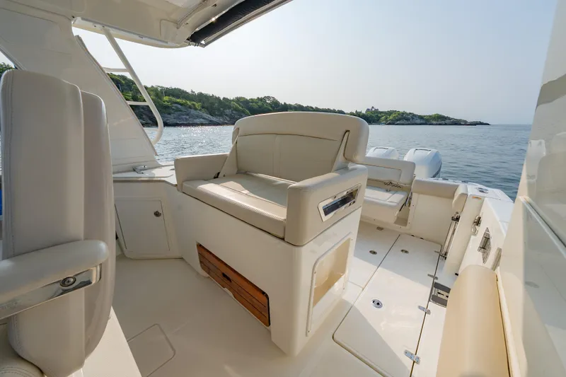 Slide: The Image of 2019 Boston Whaler 350 EX REALM boat interior with seating, on calm water. - 15