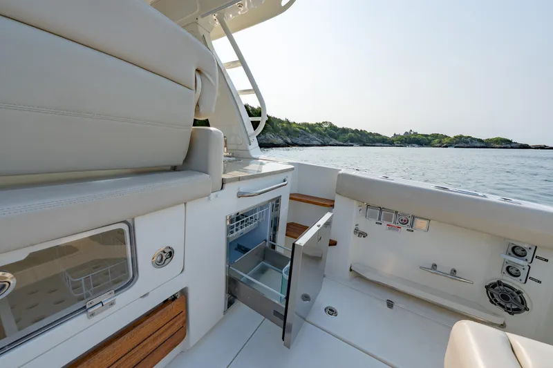 Slide: The Image of 2019 Boston Whaler 350 EX REALM interior with open storage, overlooking serene waters. - 21