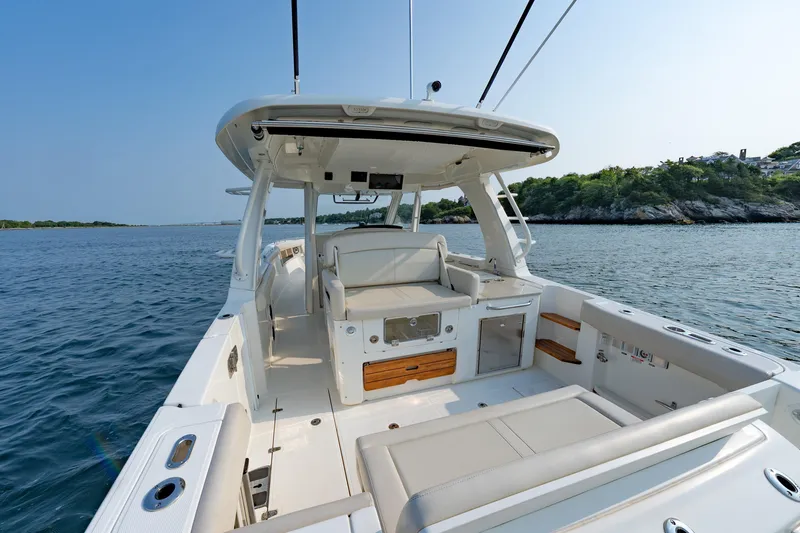 Slide: The Image of 2019 Boston Whaler 350 EX REALM boat on calm water, featuring spacious deck and seating. - 22