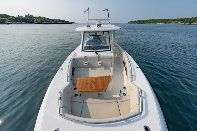 Slide: The Image of 2019 Boston Whaler 350 EX REALM boat on calm water, featuring spacious seating. - 3