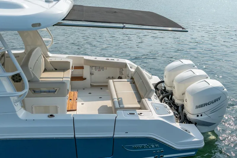Slide: The Image of 2019 Boston Whaler 350 EX REALM boat with triple Mercury engines on water. - 37