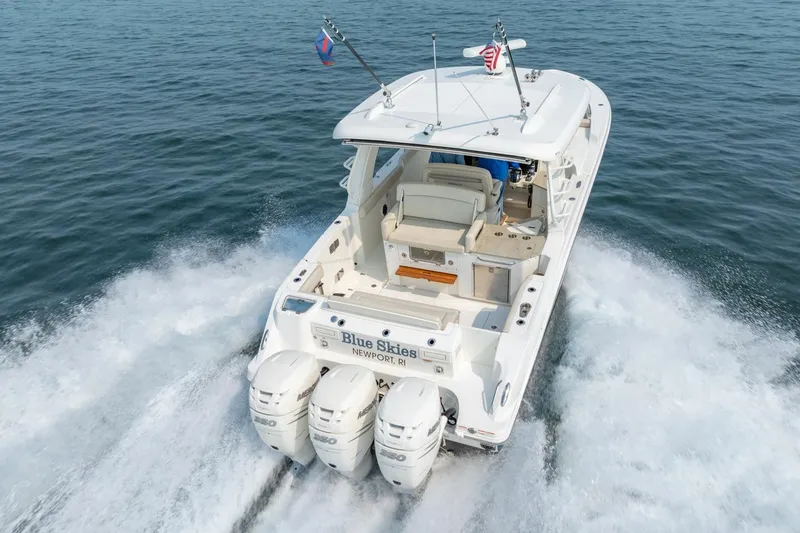 Slide: The Image of 2019 Boston Whaler 350 EX REALM cruising on open water, rear view. - 39