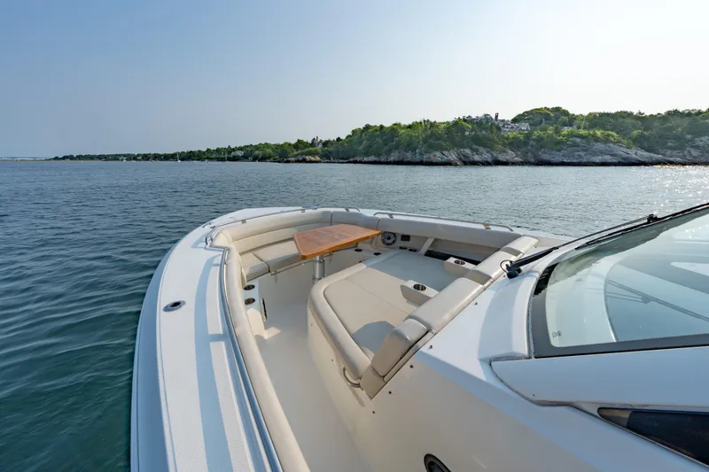 Slide: The Image of 2019 Boston Whaler 350 EX REALM boat on calm water near a scenic shoreline. - 4