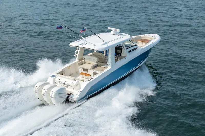 Slide: The Image of 2019 Boston Whaler 350 EX REALM cruising on open water, showcasing powerful engines. - 40