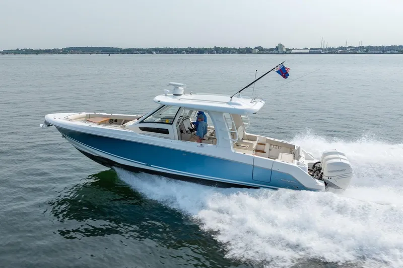 Slide: The Image of 2019 Boston Whaler 350 EX REALM cruising on open water, side view. - 49