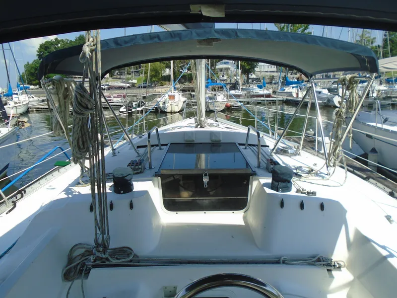 Slide: The Image of 1987 Hunter Legend 37 sailboat cockpit view in marina, featuring ropes and canopy. - 11