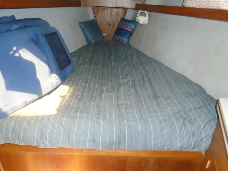 Slide: The Image of Cozy cabin bed in 1987 Hunter Legend 37 sailboat with striped bedding and pillows. - 5