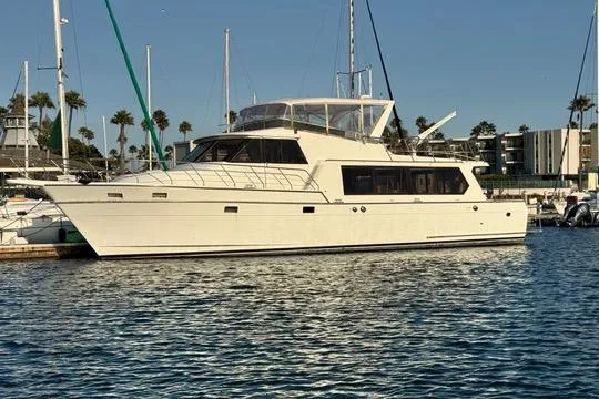 The Image of 1990 Angel Pilothouse yacht docked in a marina, surrounded by calm water and palm trees. - 0