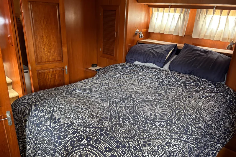Slide: The Image of Cozy bedroom in 1990 Angel Pilothouse yacht with patterned bedding and wooden interior. - 10