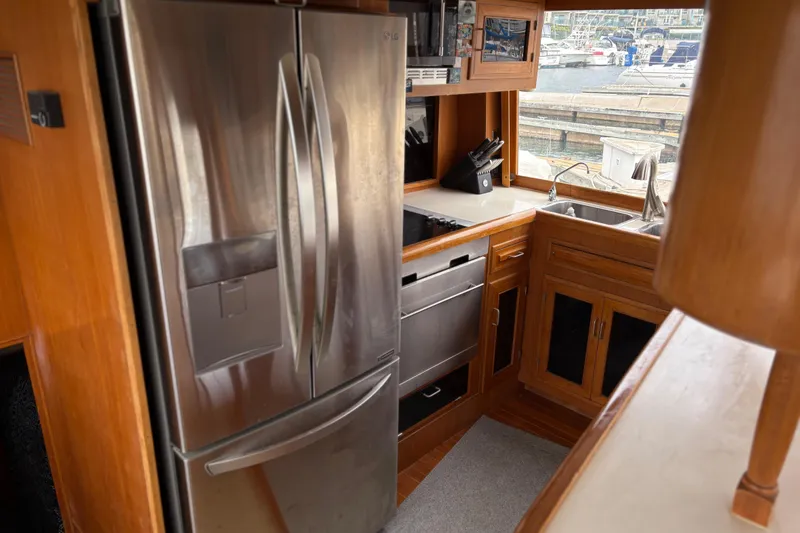 Slide: The Image of 1990 Angel Pilothouse kitchen with stainless steel appliances and wooden cabinetry. - 11