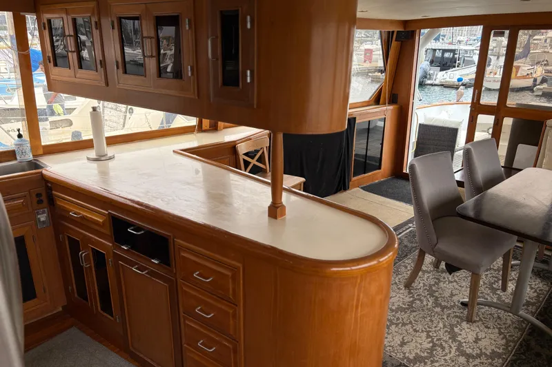 Slide: The Image of Interior of 1990 Angel Pilothouse yacht with wooden cabinetry and dining area. - 12