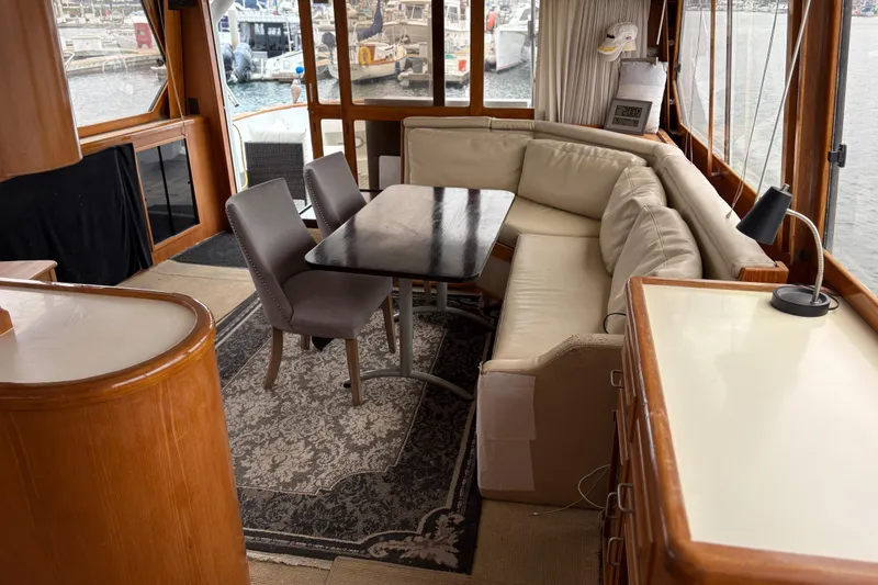 Slide: The Image of Luxurious 1990 Angel Pilothouse interior with elegant seating and dining area, overlooking marina. - 13