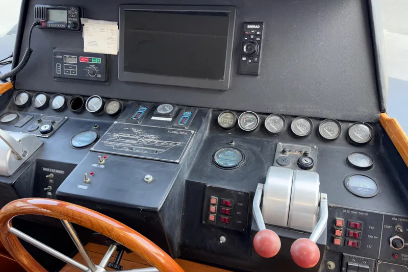 Slide: The Image of 1990 Angel Pilothouse control panel with gauges, steering wheel, and navigation equipment. - 2