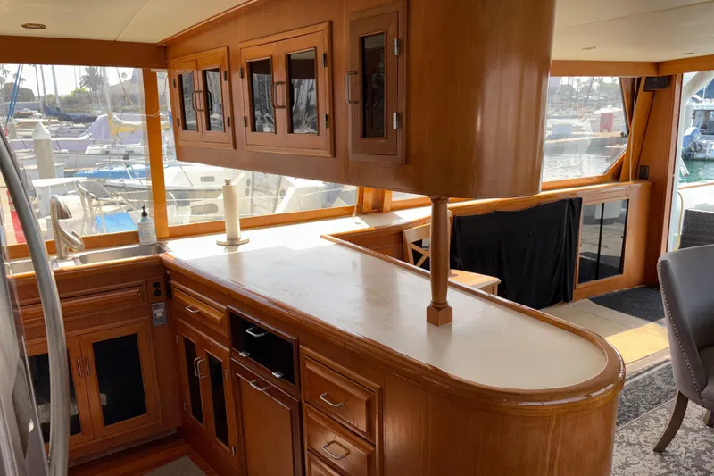 Slide: The Image of Luxurious 1990 Angel Pilothouse yacht interior with wooden cabinetry and marina view. - 24