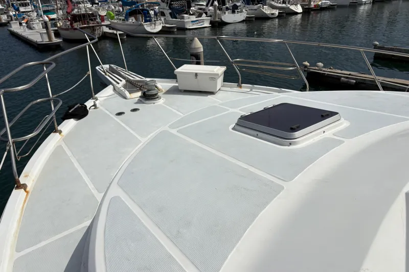 Slide: The Image of 1990 Angel Pilothouse yacht deck at marina, featuring railing and hatch. - 25