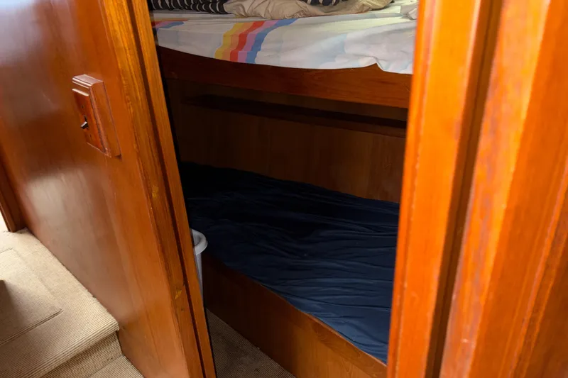Slide: The Image of Cozy wooden bunk beds inside a 1990 Angel Pilothouse boat cabin. - 27
