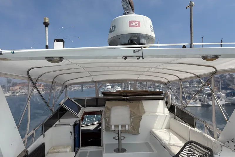 Slide: The Image of 1990 Angel Pilothouse boat interior with seating and navigation equipment, docked in a marina. - 28