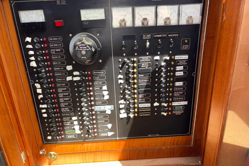 Slide: The Image of Electrical control panel on a 1990 Angel Pilothouse boat, featuring switches and gauges. - 29