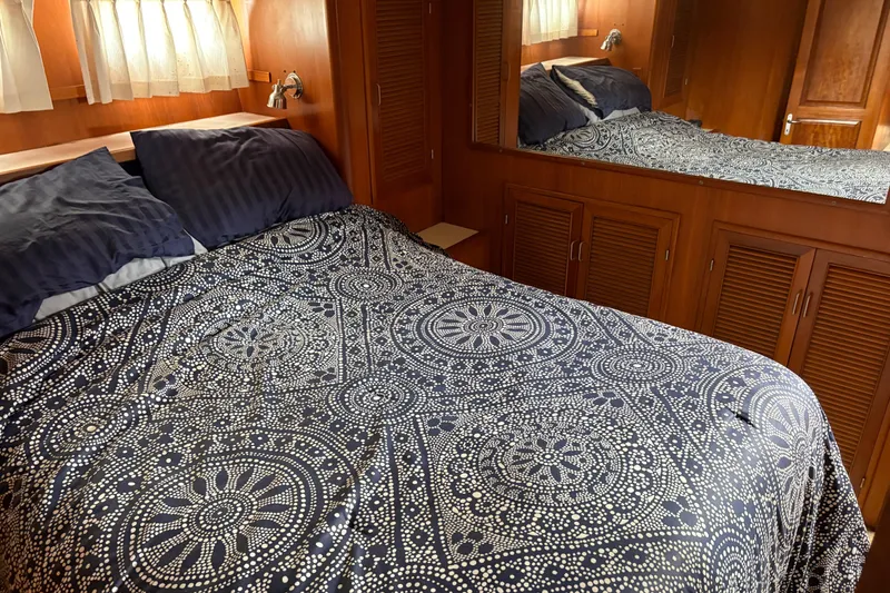 Slide: The Image of Cozy bedroom in 1990 Angel Pilothouse with patterned bedding and wooden cabinetry. - 7