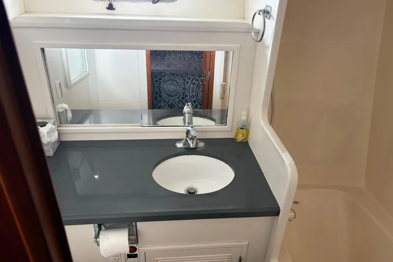 Slide: The Image of Bathroom sink area in a 1990 Angel Pilothouse boat, featuring a mirror and countertop. - 9