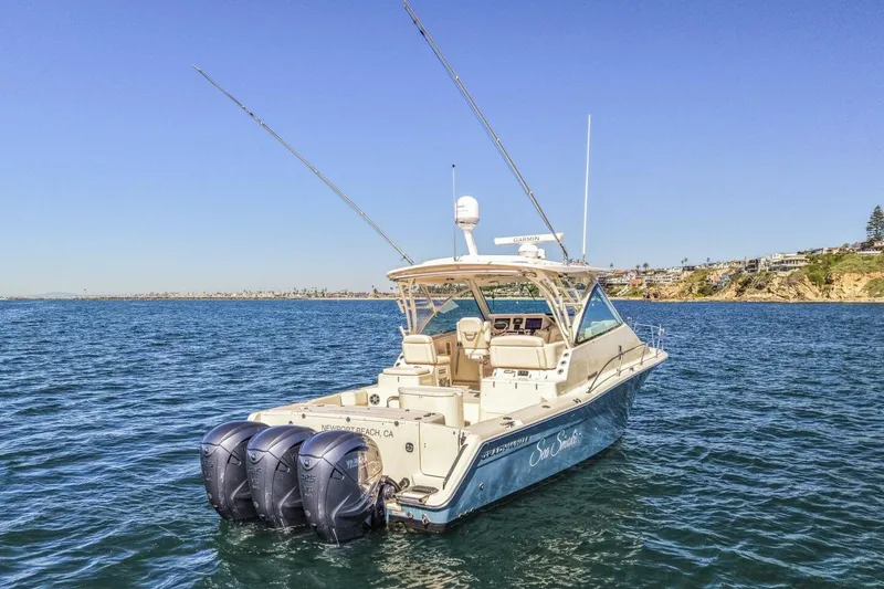 Slide: The Image of 2019 Grady-White Express 370 boat on open water, featuring triple outboard engines. - 19