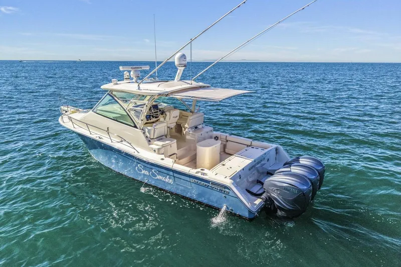 Slide: The Image of 2019 Grady-White Express 370 boat on open water, featuring triple outboard engines. - 25