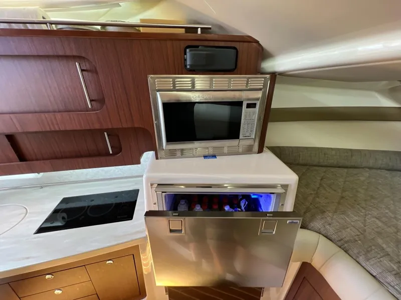 Slide: The Image of 2019 Grady-White Express 370 interior with microwave and open fridge in cabin. - 9