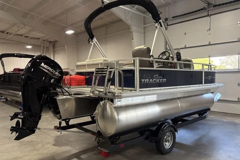Slide: The Image of 2026 Sun Tracker Bass Buggy 16 XL Select pontoon boat in a garage setting. - 4