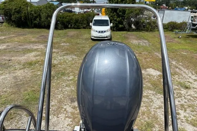 Slide: The Image of 2022 Sun Catcher 322 SS boat engine with metal frame, parked on grassy area. - 19