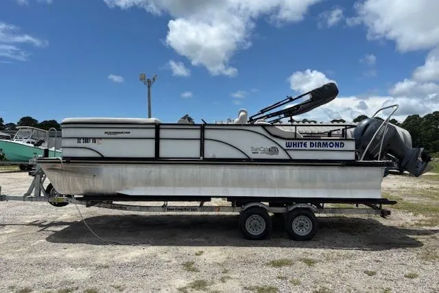 Slide: The Image of 2022 Sun Catcher 322 SS pontoon boat on trailer under blue sky. - 3