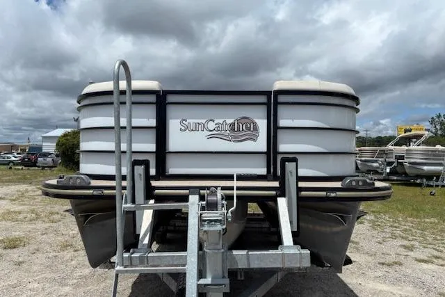 Slide: The Image of 2022 Sun Catcher 322 SS pontoon boat on trailer under cloudy sky. - 4